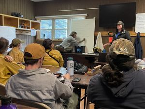 Academy participants sitting at table learning about the basics of prescribed fire.