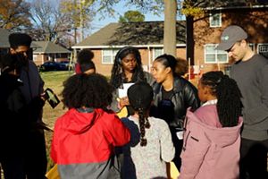 A group of girls stand together with two TNC staff members.