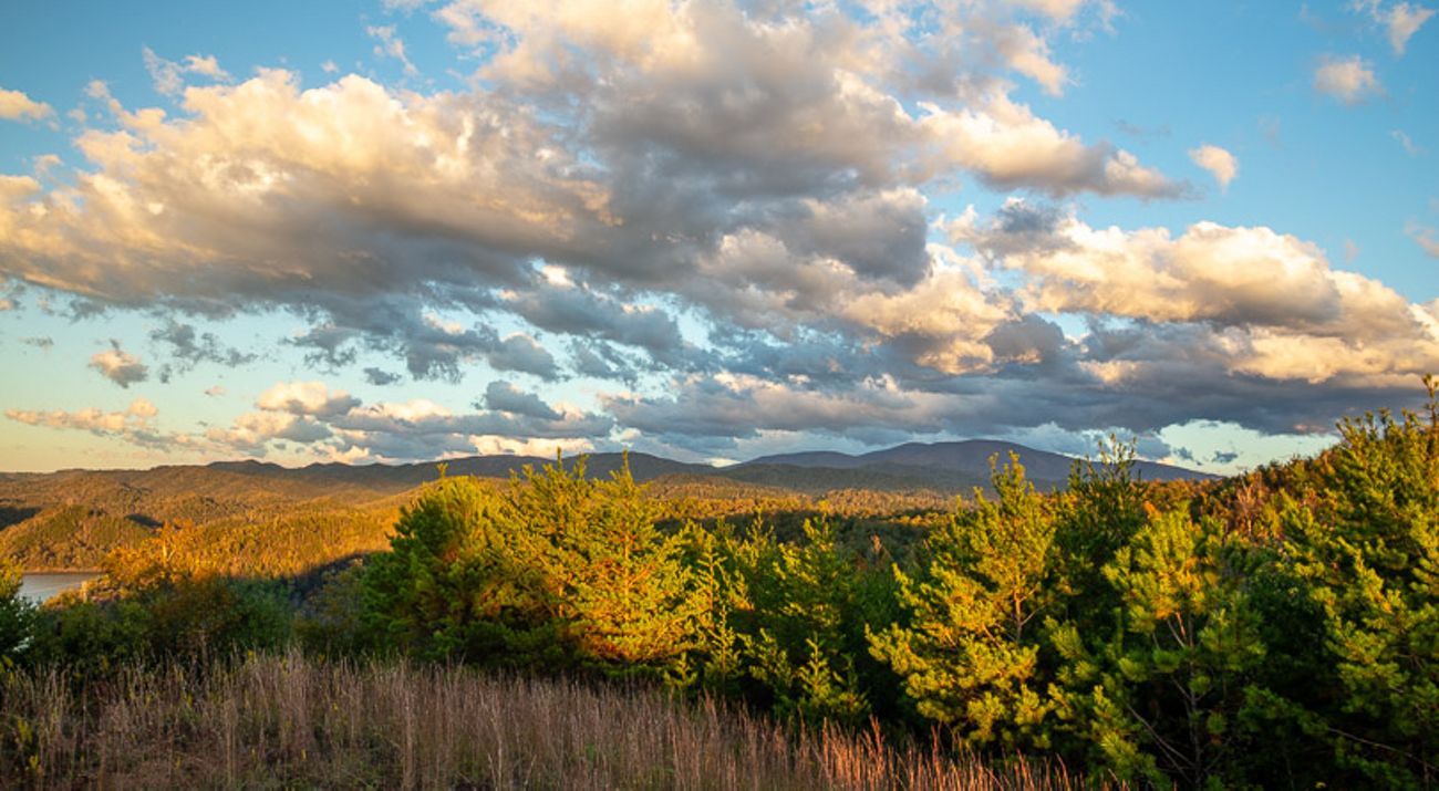 Clouds hover over a sunny mountain valley.