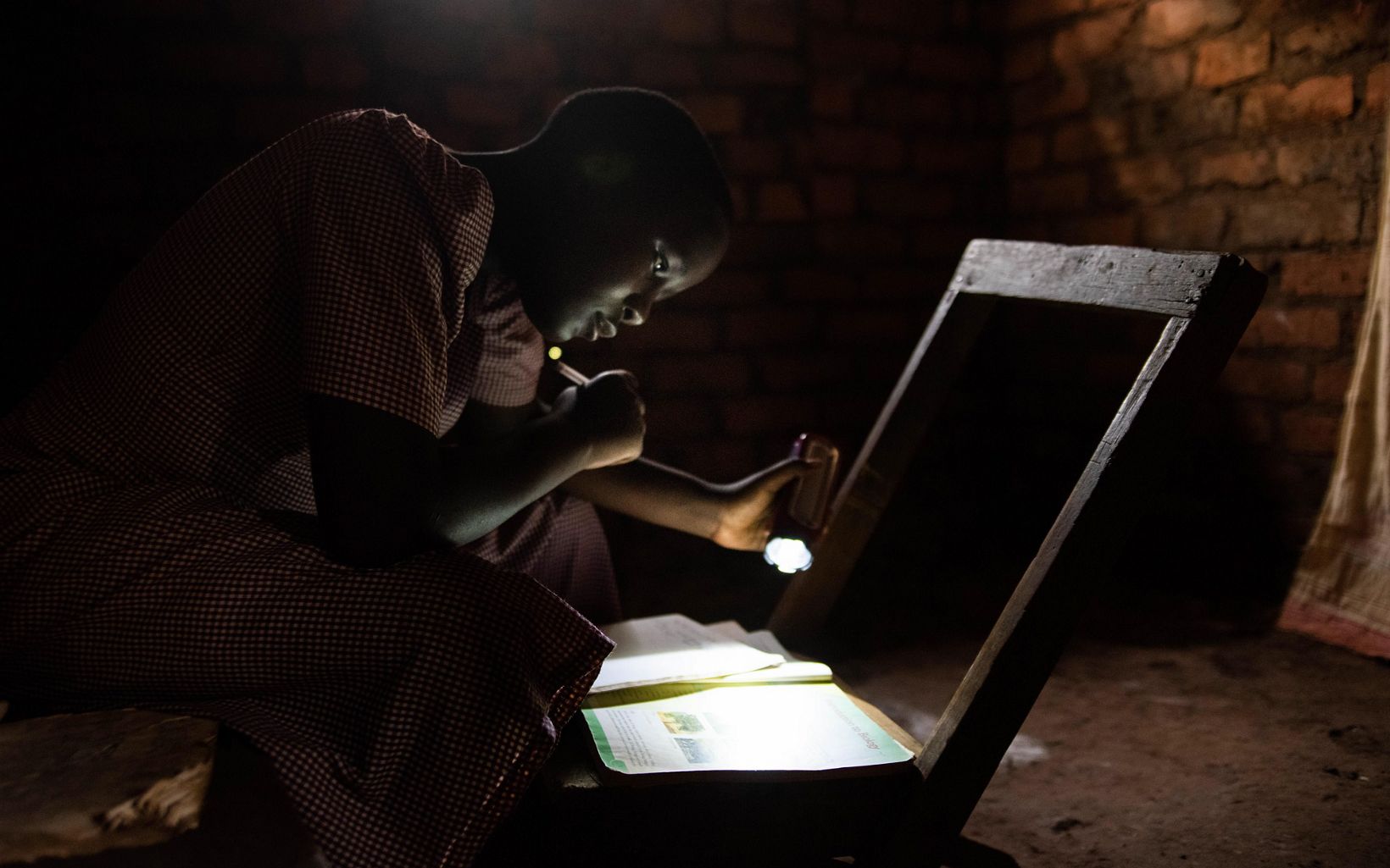 
                
                  Night Study After Teresia completed her chores, she would attempt to study by flashlight because her home had no electricity. 
                  © Roshni Lodhia
                
              