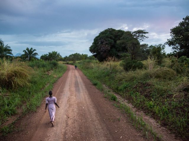 A girl walks down a long road 