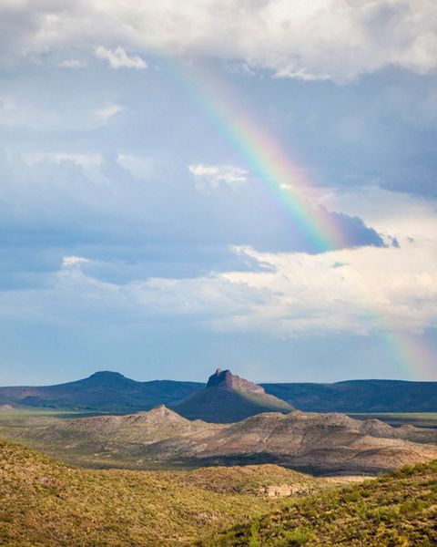 A rainbow stretches over a mountain in West Texas.