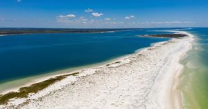 A strip of sand streteches out into ocean waters.