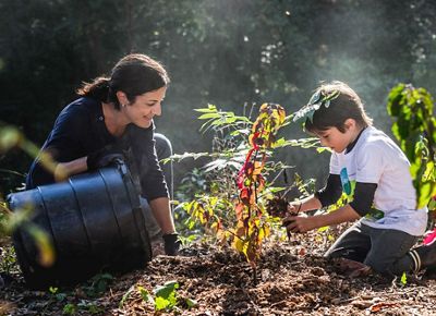 Woman and child planting tree.