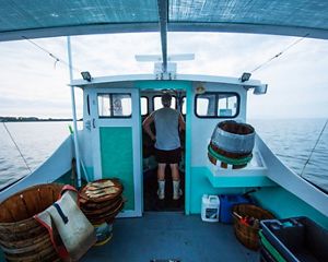 A man stands in the wheelhouse of a crab boat.