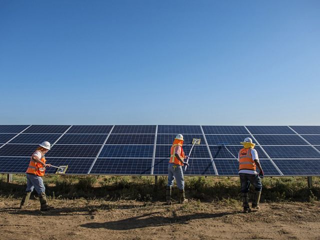 Worker's clean solar panels for maximum efficiency at the power solar facility in Lancaster, California. Photo credit: © Dave Lauridsen