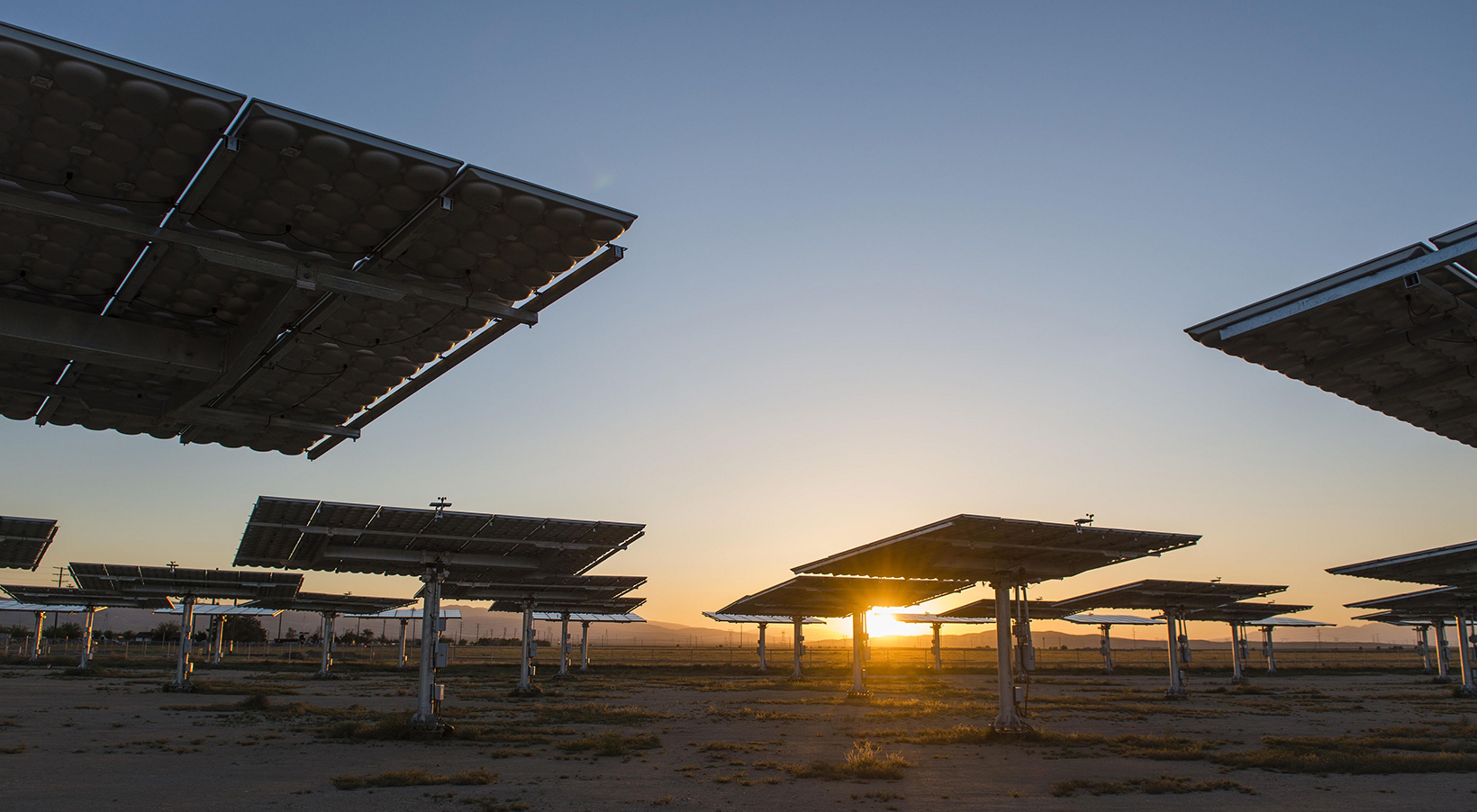 Photo of solar panels in a desert environment as the sun sets in Antelope Valley, California.