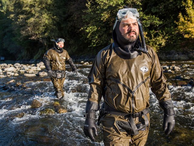 Two men in snorkeling gear cross Blue Creek