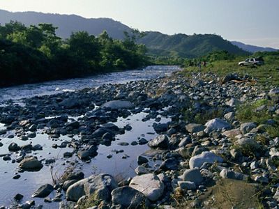 A river flows west off the Sierra Madre watershed through the agricultural community of Vienes Comunales San Antonio towards Pijijiapan and the Pacific ocean; Chiapas, Mexico.