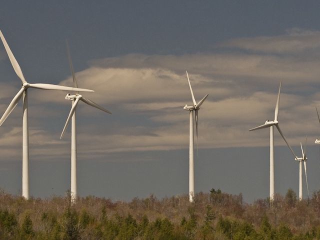six wind turbines against blue sky backdrop