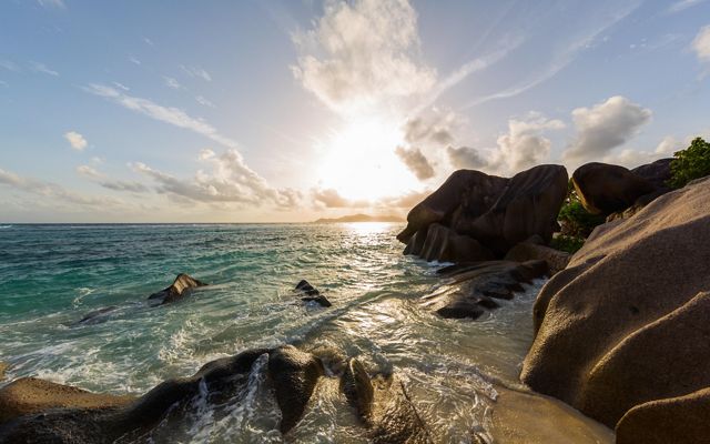 Worn granite rocks in the surf and sand define the coastlines of Seychelles's inner islands.