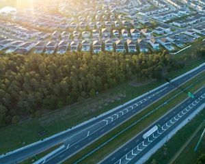 toll highway next to cookie cutter housing development