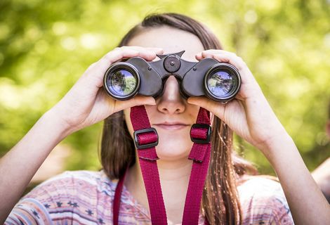 Joven observa por binoculares
