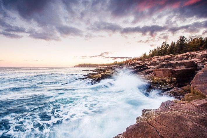 White foamed waves crash against the rocky coast of Maine.