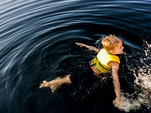 Photo of a boy swimming in water.