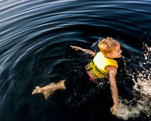 Photo of a boy swimming in water.