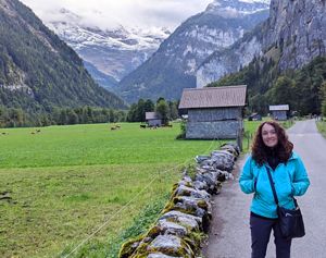 Candid portrait of Ann Nallo standing on a path with mountains behind her.
