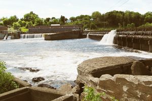 The Penobscot River flows over a dam with mill buildings on the far shore.