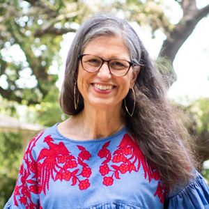 A woman with glasses smiles