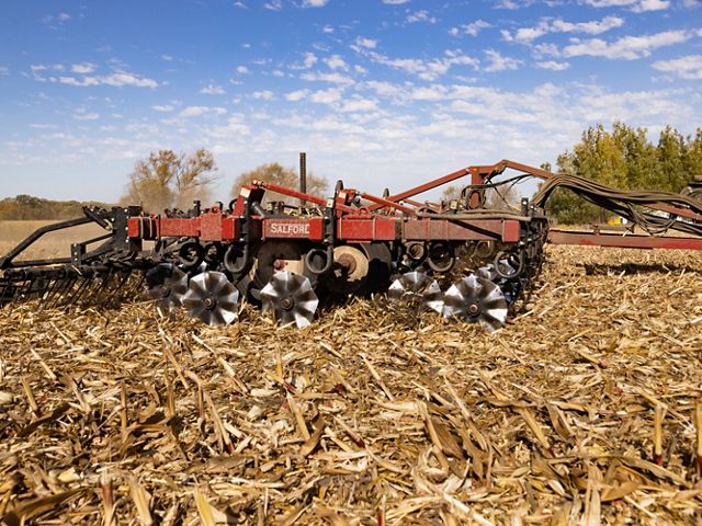 Vertical plow in a cornfield on a sunny day.