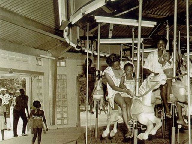 Historical photo of families and children riding the carousel at Virginia Key Beach. 