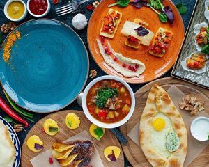 a spread of brightly colored food and dinner plates on a table