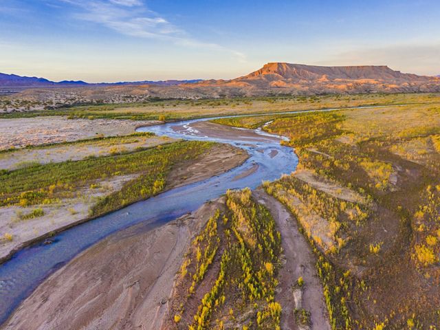 Aerial view of the Virgin River at sunset with mountains in the background.