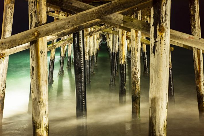 The support beams of Balboa Pier at night.