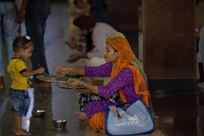A mother and her child share a plate of food.