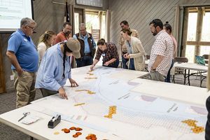 A group of people gather around a map.