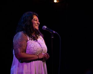 Lylianna Allala speaks into a microphone.