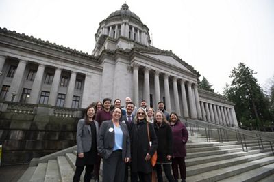 A group of people stand on steps to pose for a picture. 