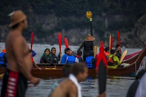 Group of people paddling in a canoe.