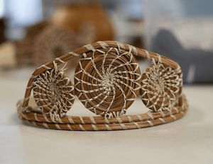 Longleaf pine needle weaving. Light brown needles form crown, white grasses add embellishment. 