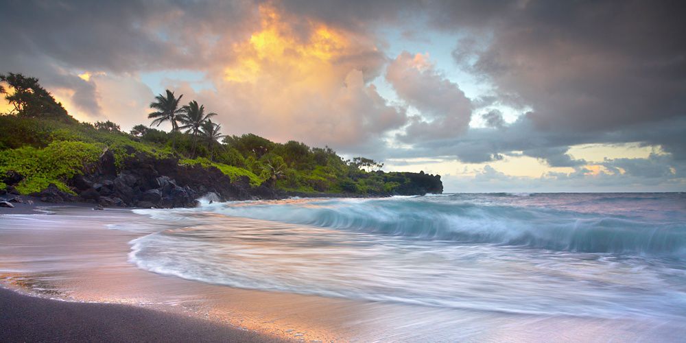 Sunrise on a beach with palm trees.