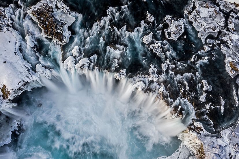 An aerial view of an icy waterfall in Iceland.