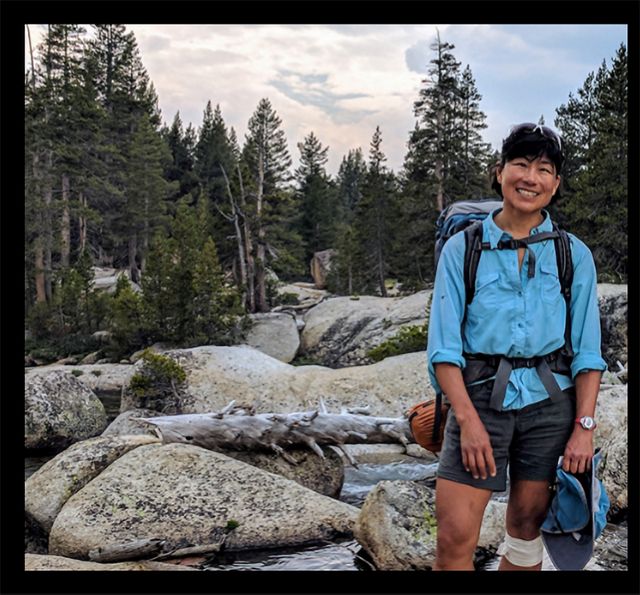 Sally Liu backpacking near a river.