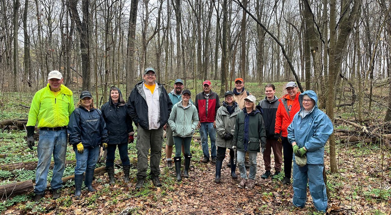 Group of people poses for a photo in a natural area.