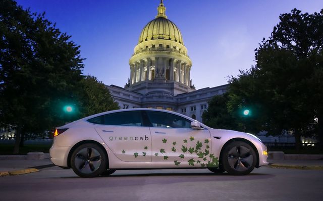 Green energy car parked in front of Wisconsin state capitol building.