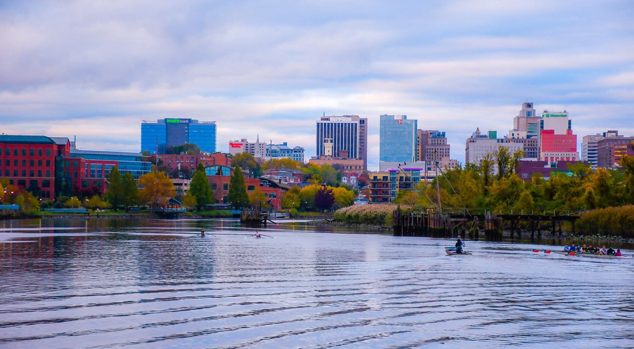 A view of a city skyline in front of a body of water.