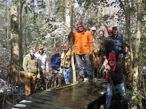 A group of people pose together during a stewardship workday at a preserve.