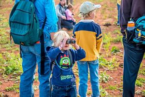 Child looks through binoculars.