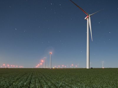 Wind turbines towering over agricultural field