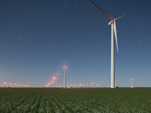 Rows of wind turbines across a Kansas farm create responsible renewable wind energy.