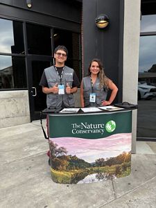 Two F2F canvassers pose outside of a building behind a TNC banner.