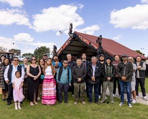 Several people stand together outside and pose for a group photo.