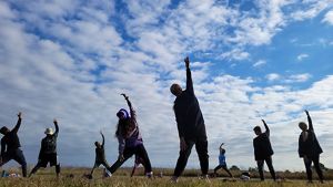 Small group of people practice yoga on the Kankakee Sands prairie.