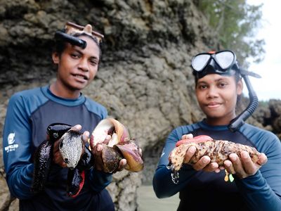 Generasi muda Kelompok Sasi Perempuan Waifuna, Yolanda Kacili (kiri) dan Yonance Hay (kanan), bersama hasil tangkapan mereka pada buka sasi di Kampung Kapatcol, Distrik Missol Barat, Kabupaten Raja Ampat, Provinsi Papua Barat Daya, Senin, 25 Maret 2024.