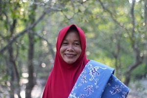 Salah seorang anggota kelompok perempuan Kampung Teluk Semanting membawa produk batik hasil karya mereka.
