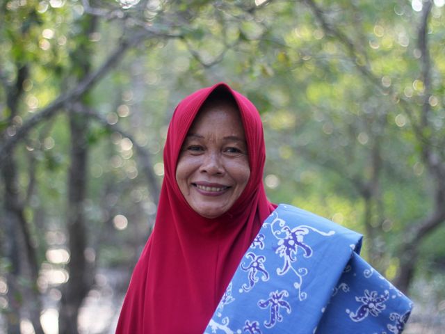 Salah seorang anggota kelompok perempuan Kampung Teluk Semanting membawa produk batik hasil karya mereka.